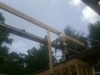 Carpenter setting a ridge beam over a new addition frame — Ice Dam Removal by Roofing Brothers in Russells Point