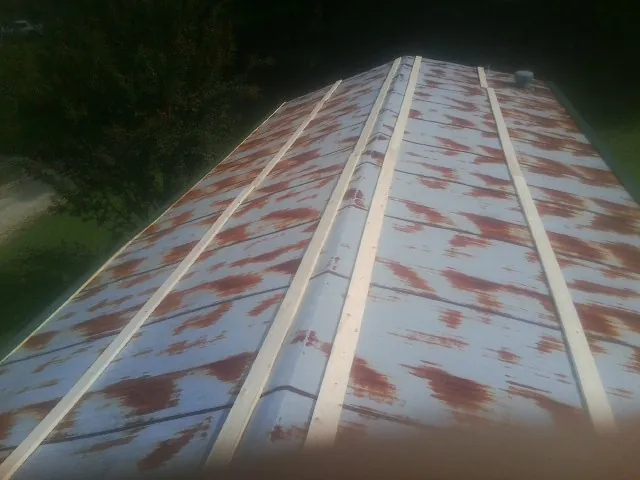 Rusted metal roof panels with new wood purlins before replacement — Storm Damage Roof Repair in Russells Point by Roofing Brothers