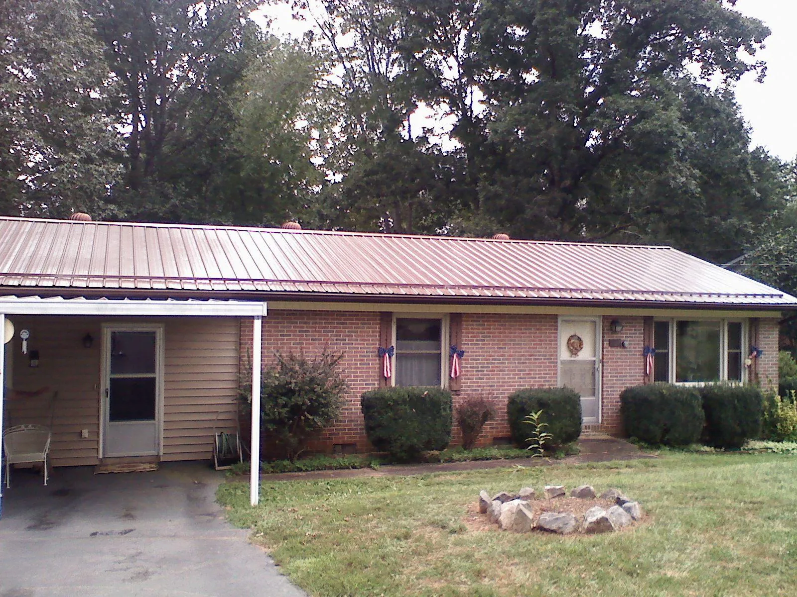 Bronze metal roof and carport on a brick ranch home — Roof Repair work by our crew in Russells Point